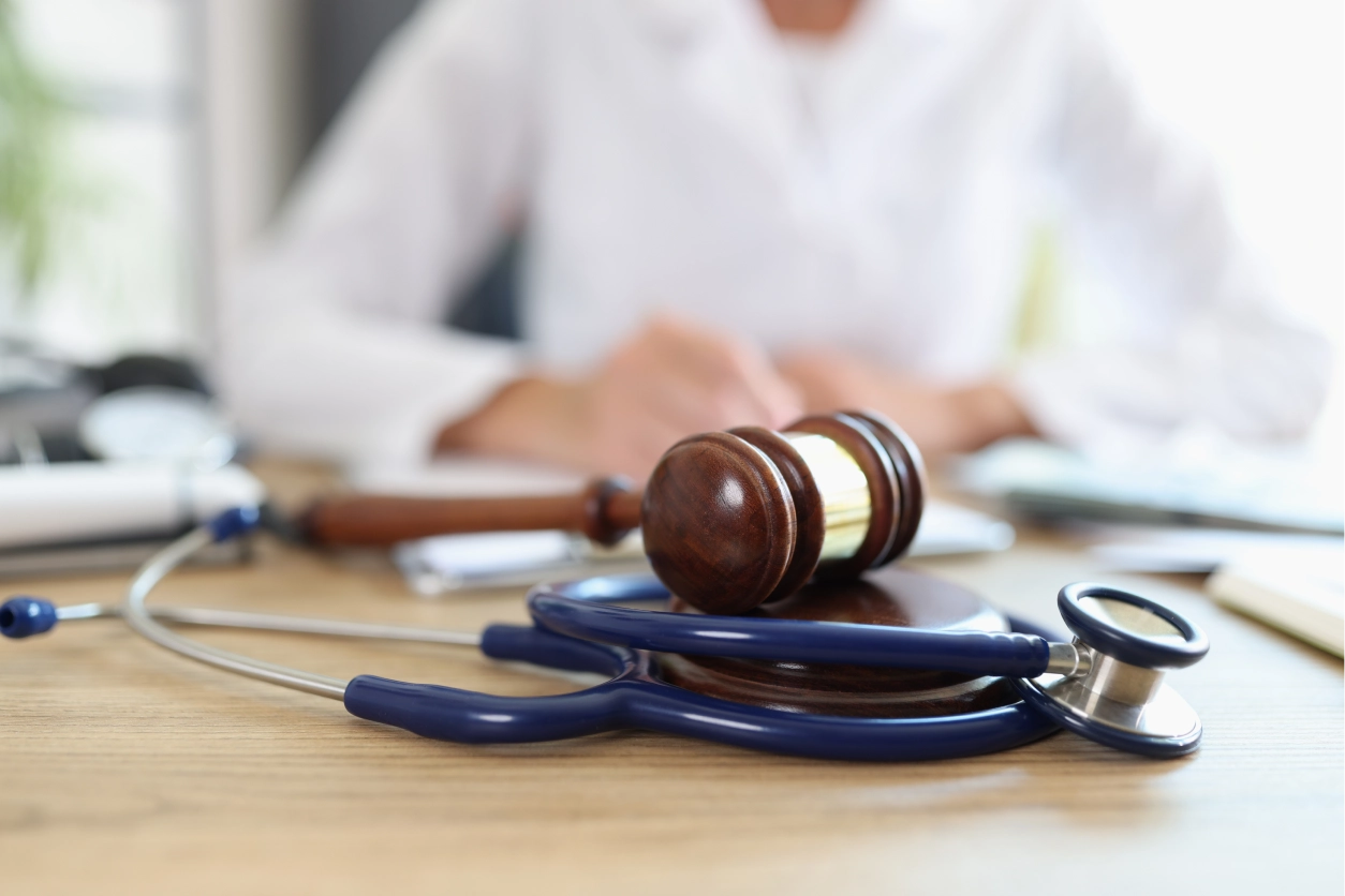 Stethoscope and gavel on wooden table.