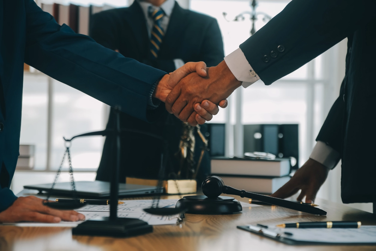 Handshake over legal documents and gavel